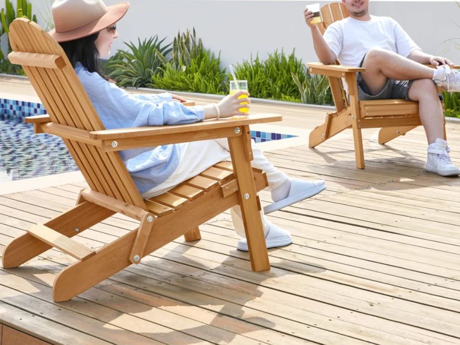 Rosecliff Heights Bennir Fir Solid Wood Foldable Adirondack Set of 2 with a man and a woman sitting in them