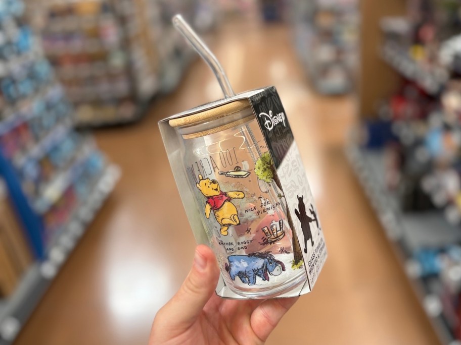 a hand holding a a glass tumbler with straw