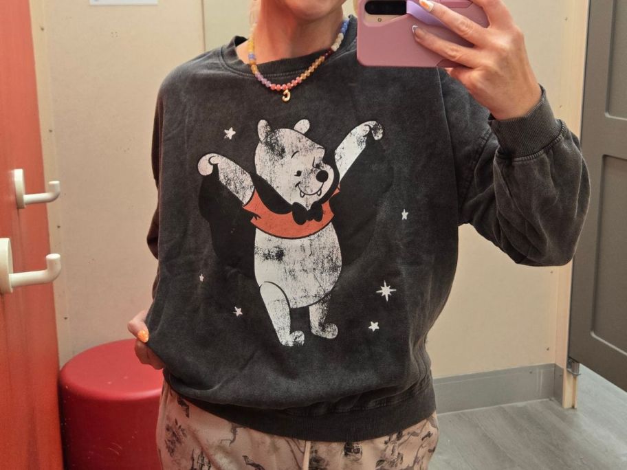 stefanie wearing Winnie the Pooh Women's Crewneck Fleece Graphic Pullover Sweatshirt in store fitting room
