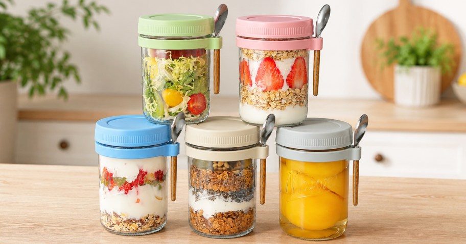 stack of glass containers layered with oats and fruits on a counter