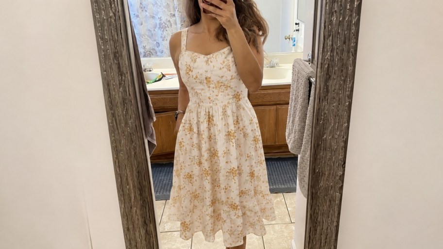 a woman in a floral print dress taking a selfie