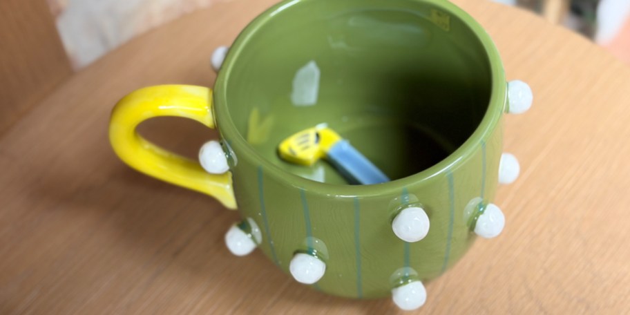 green and yellow mug on table