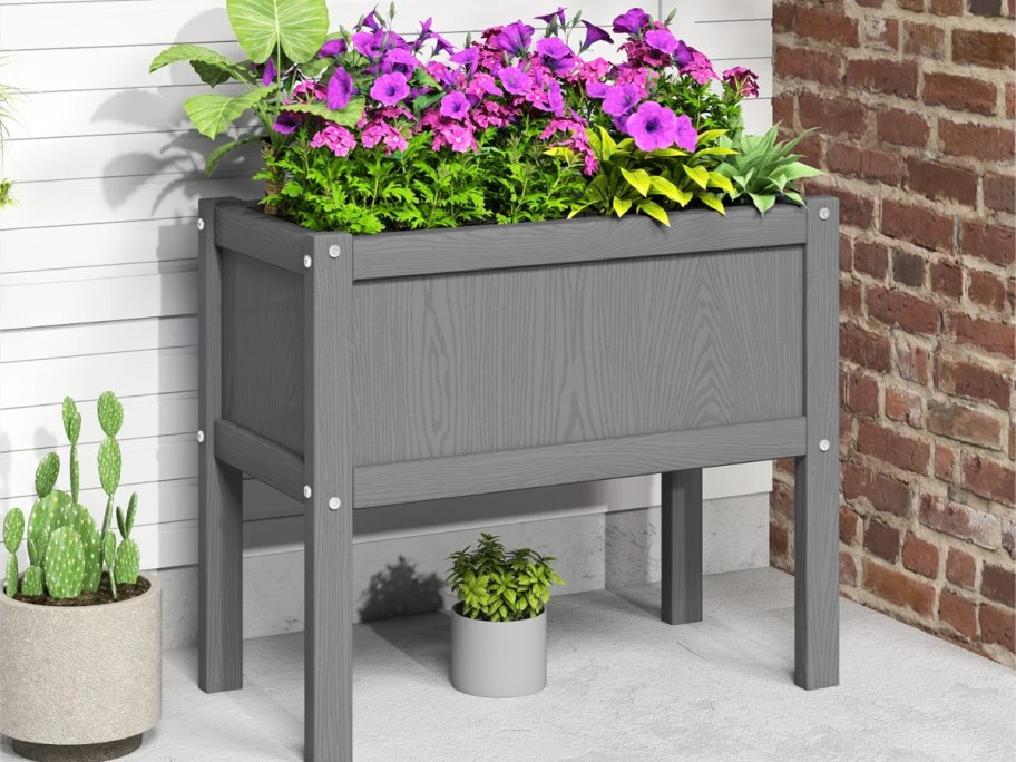gray elevated planter box on porch with purple flowers 