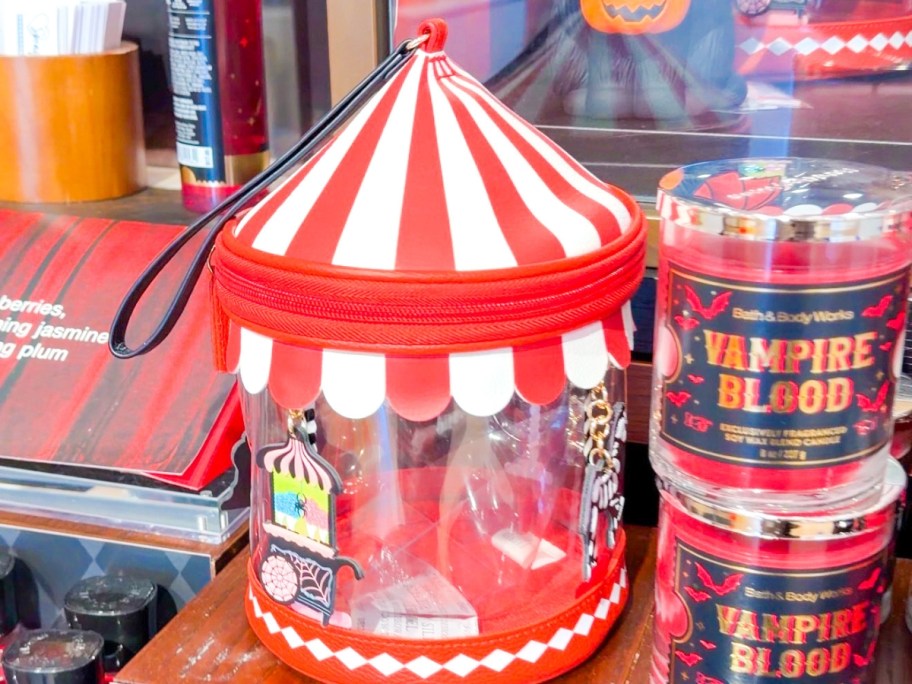 a Halloween carousel shaped wristlet next to candles