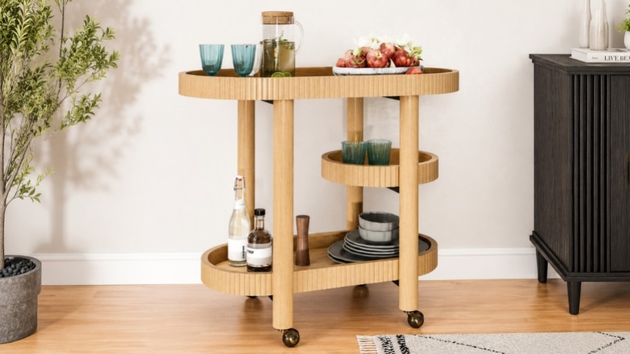 honey colored bar cart with glasses and bottles displayed