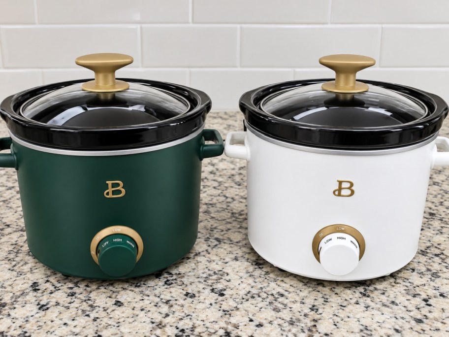 a green and a white slow cooker on a kitchen counter