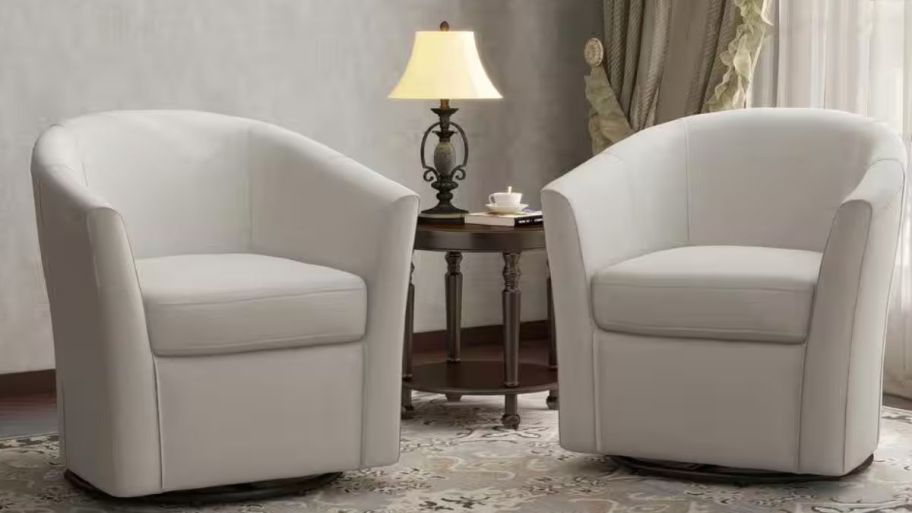 two beige swivel chairs in the living room on a rug