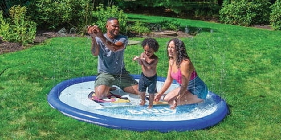 family on splash pad in yard