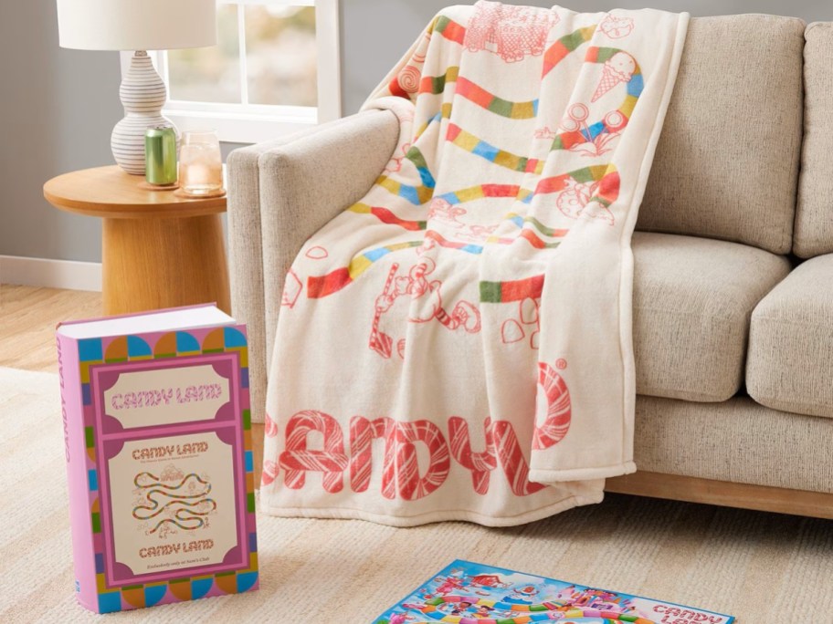 candyland print blanket draped over a couch with the box nearby