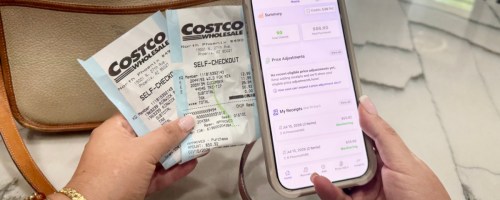 hands holding costco receipts and a phone