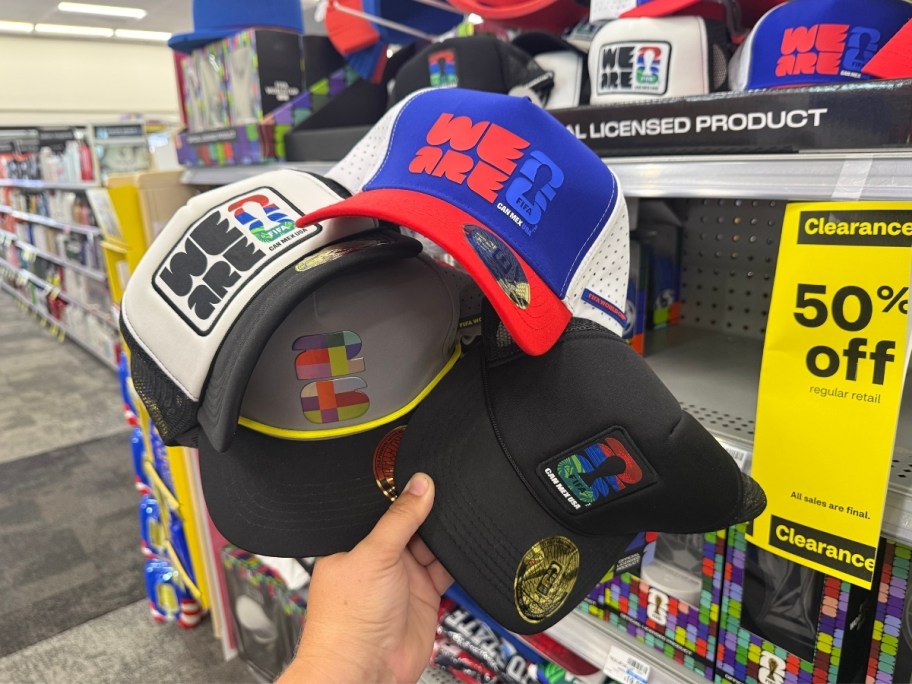 a hand holding 3 fifa caps