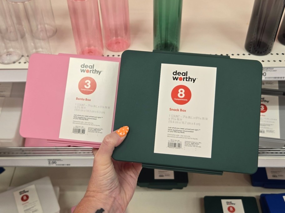 holding a pink and green bento box