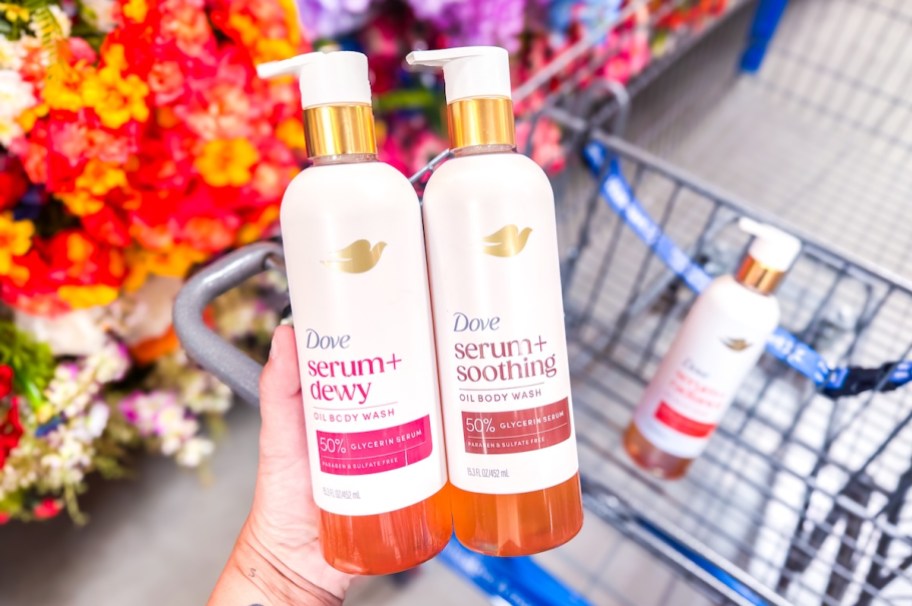 hand holding dove serum+ oil body wash bottles over cart