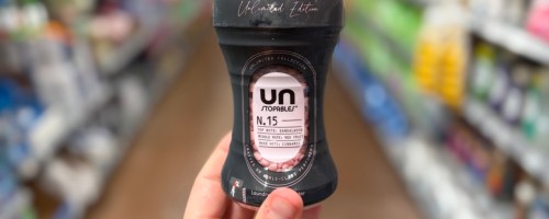 hand holding a small bottle of scent beads in a store aisle