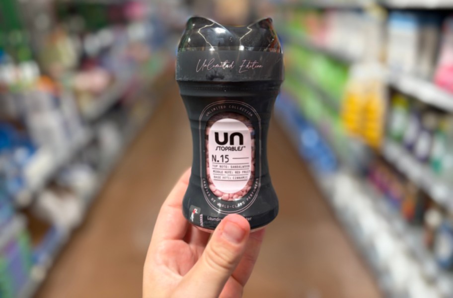 hand holding a small bottle of scent beads in a store aisle