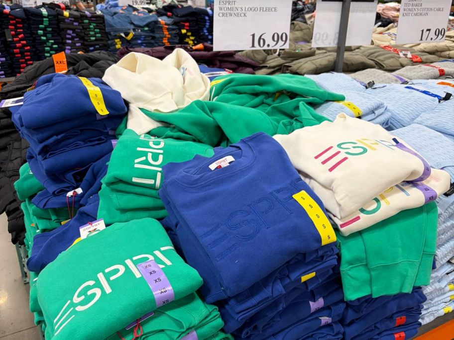 Costco display of esprit crewneck sweaters on top of the table with price behind it
