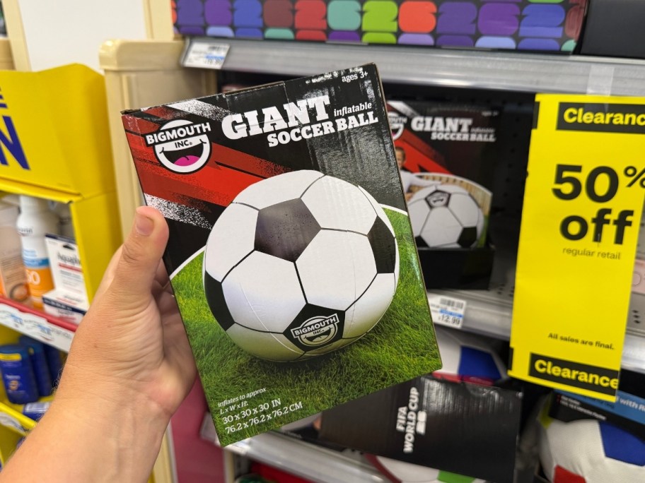 a hand holding a a ginat inflatable soccer ball