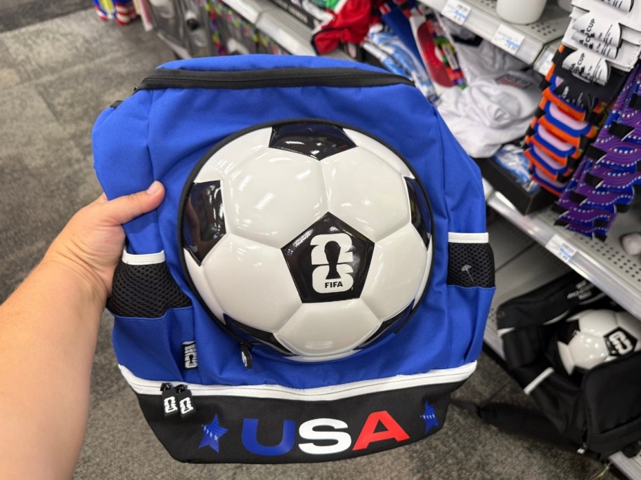 a womans hand holding a soccer backpack
