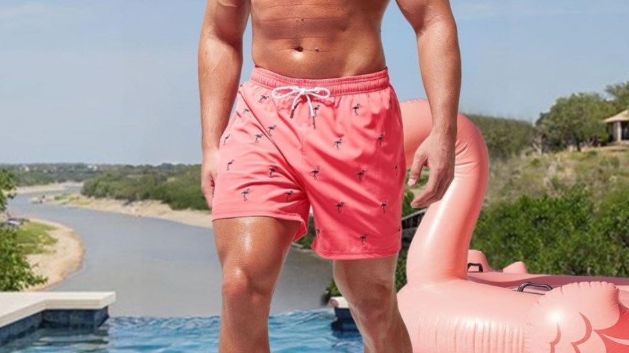 a man in a pair of pink flamingo print swim trunks