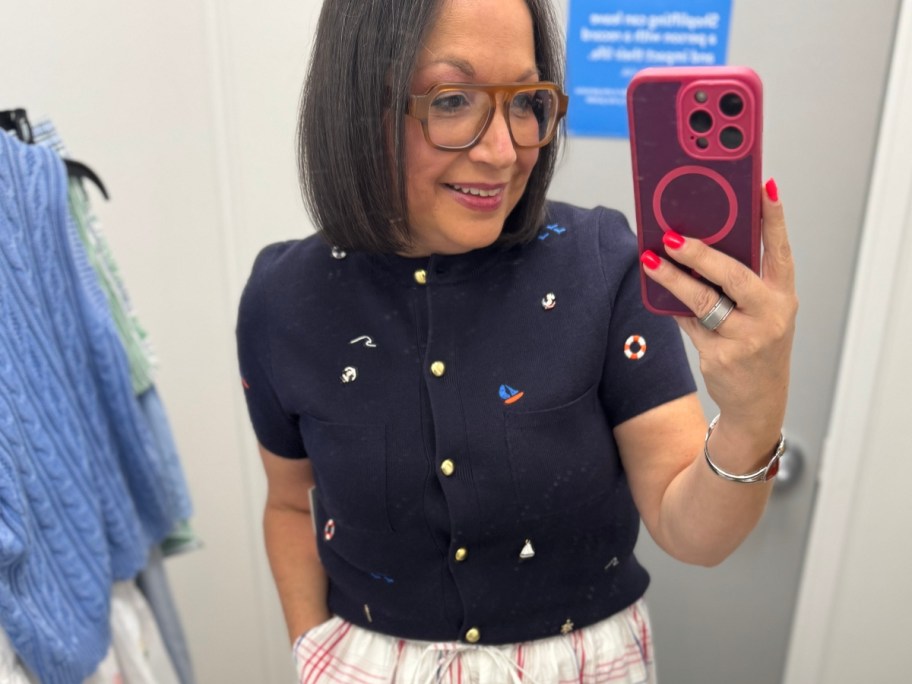 woman in navy cardigan taking selfie
