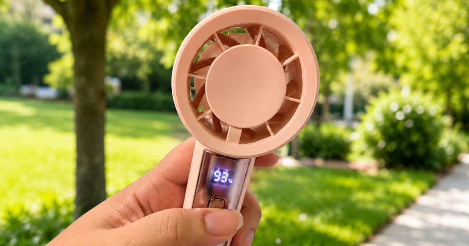 person holding a pink portable fan