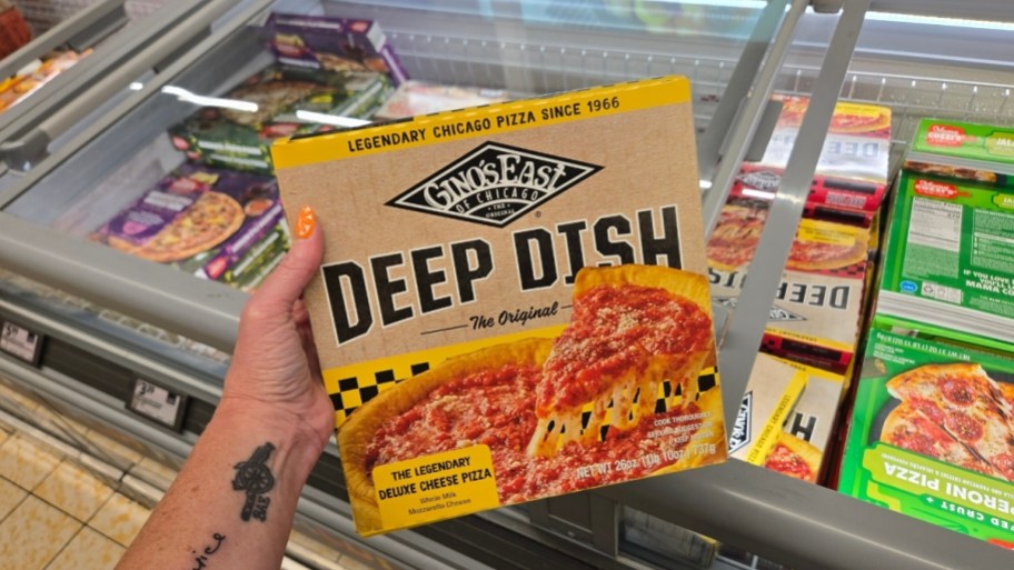 a hand holding a deep dish frozen pizza box