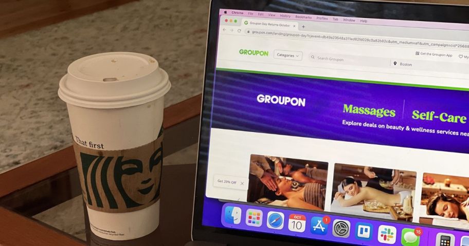 laptop with groupon website in it next to starbucks cup