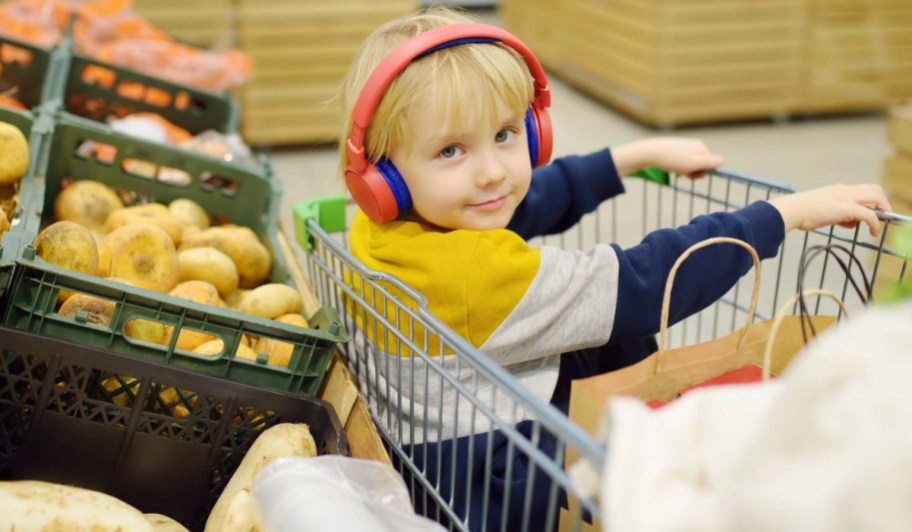 kid with headphones in shopping cart
