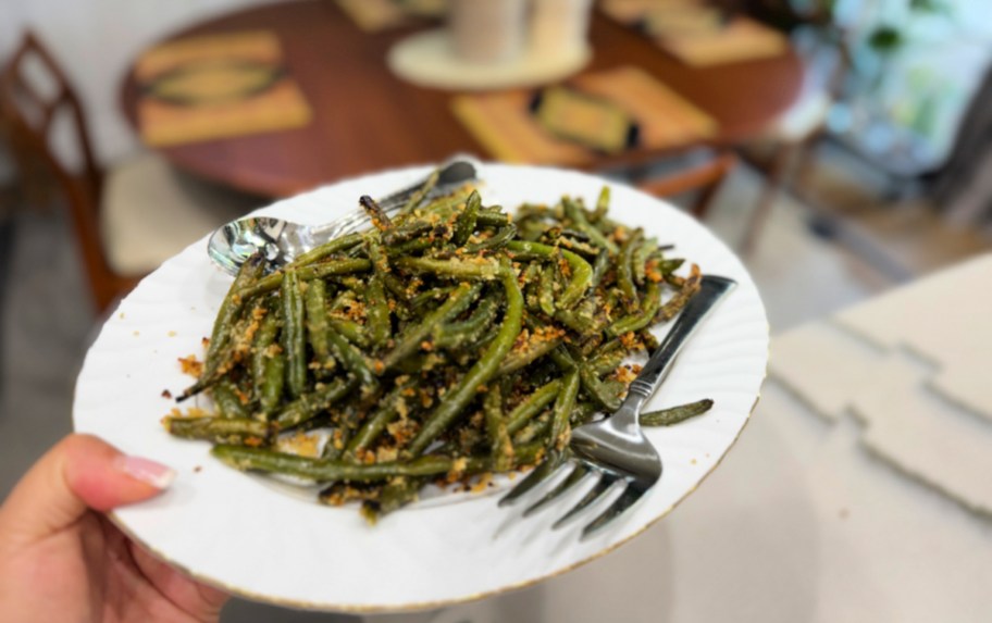 holding a platter with roasted frozen green beans