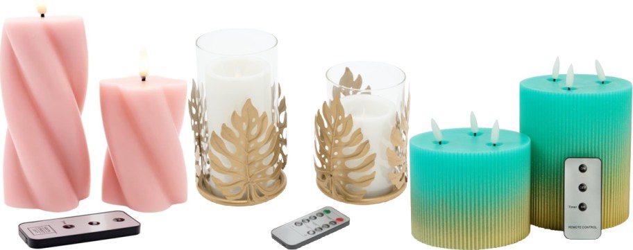 An assortment of flameless LED candles with remotes, featuring tall twisted pink candles on the left, white candles in gold monstera leaf glass holders in the center, and ribbed teal-to-gold gradient multi-wick candles on the right.