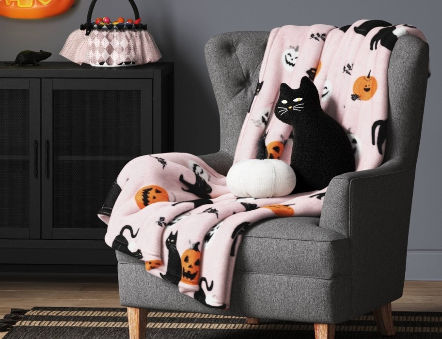 cat and pumpkin throw pillows and cat throw on a chair