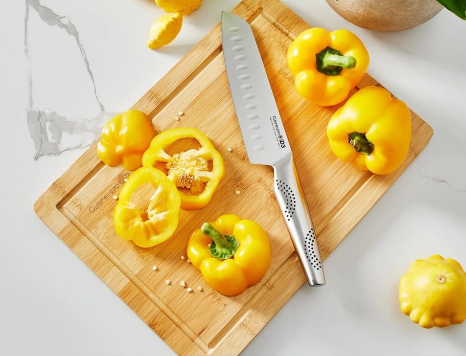 wood cutting board and knife with slicing yellow pepper