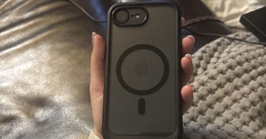 Hand holding an iPhone in a black case