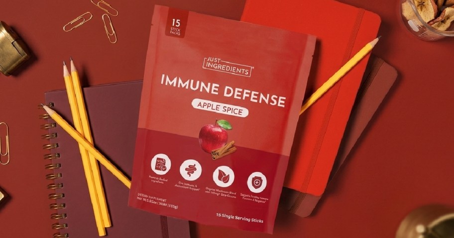 bag of red vitamins on a red background with pencils