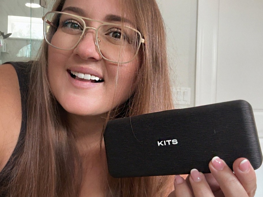 woman wearing gold glasses holding case