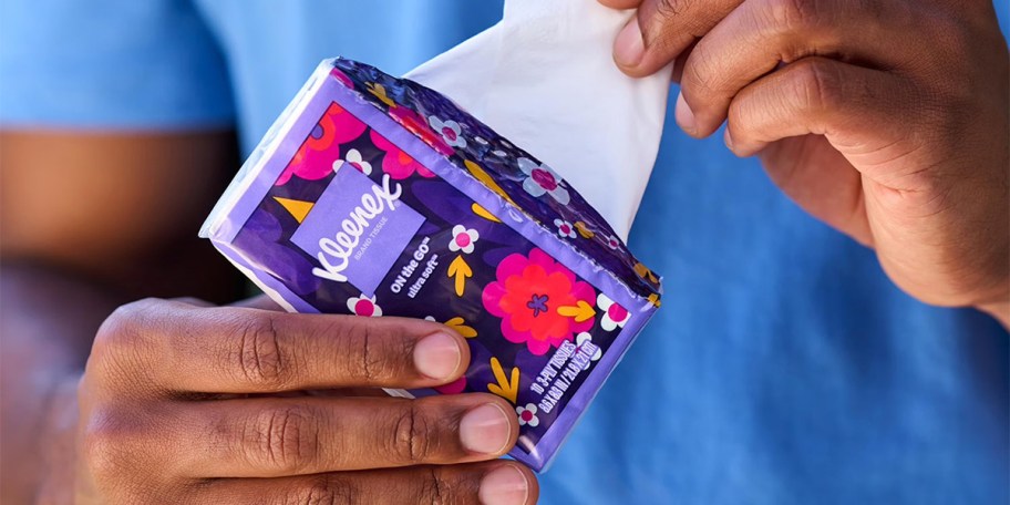 hand holding tissue pack taking one out 
