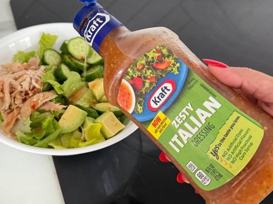 pouring Italian dressing onto a salad