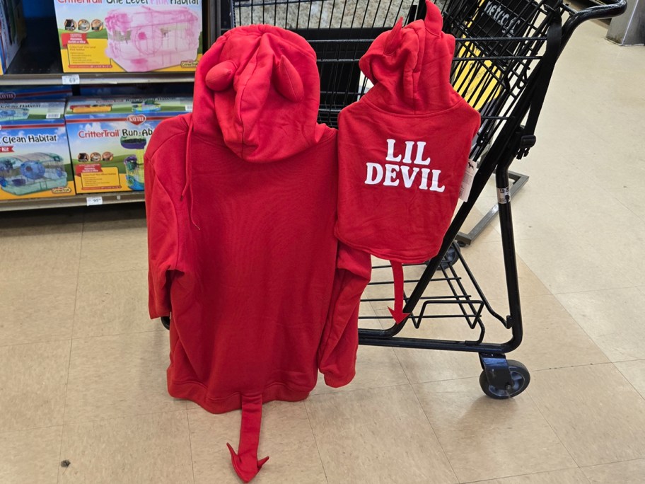 large red and small lil devil hoodies hanging on shopping cart 