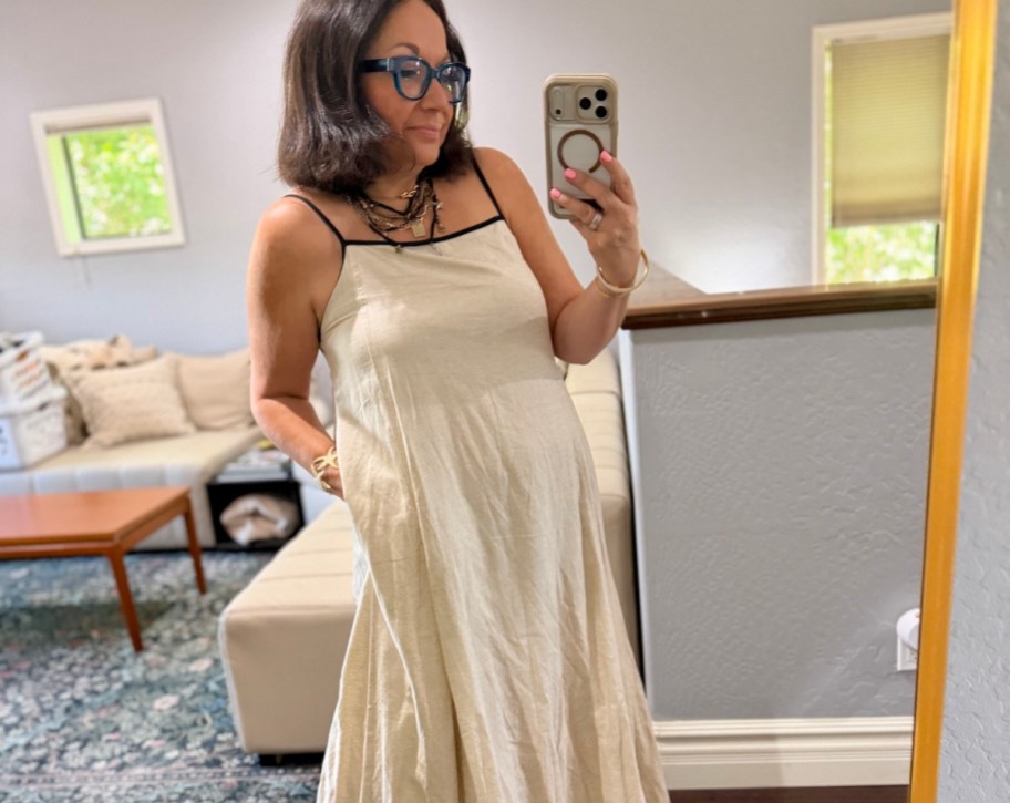 woman taking selfie in mirror wearing linen dress