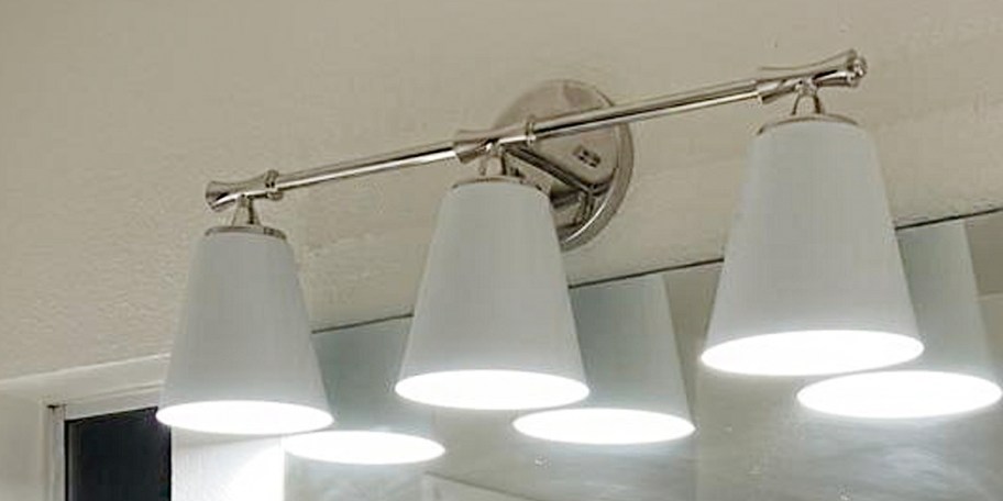 white 3 light vanity hanging about mirror