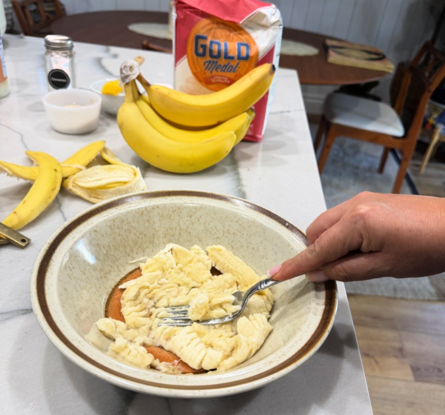mashing a banana onto a bowl