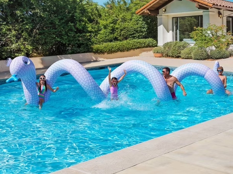 people in pool with giant snake float 