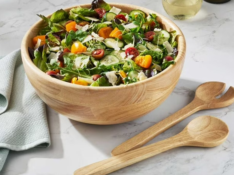 wood salad bowl with utensils on table