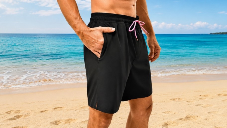 man wearing pair of black swim trunks with pink ties