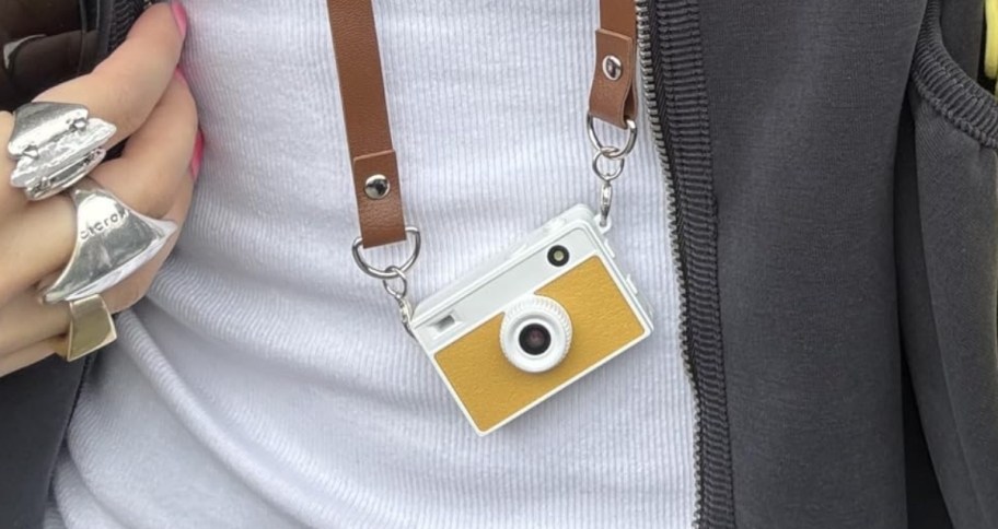 woman with a min camera around her neck
