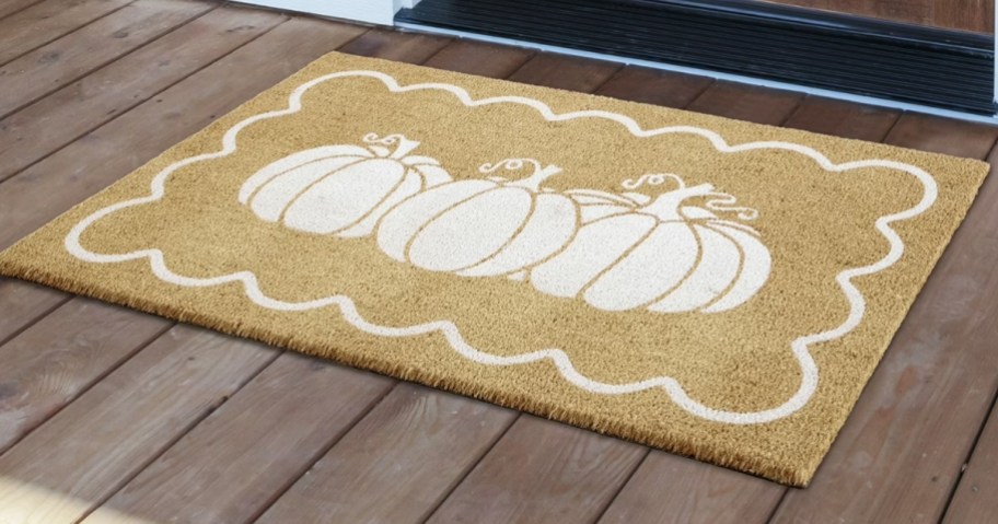 a large doormat with white pumpkins on it