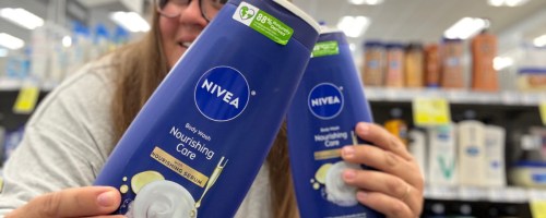 woman holding two body washes in store