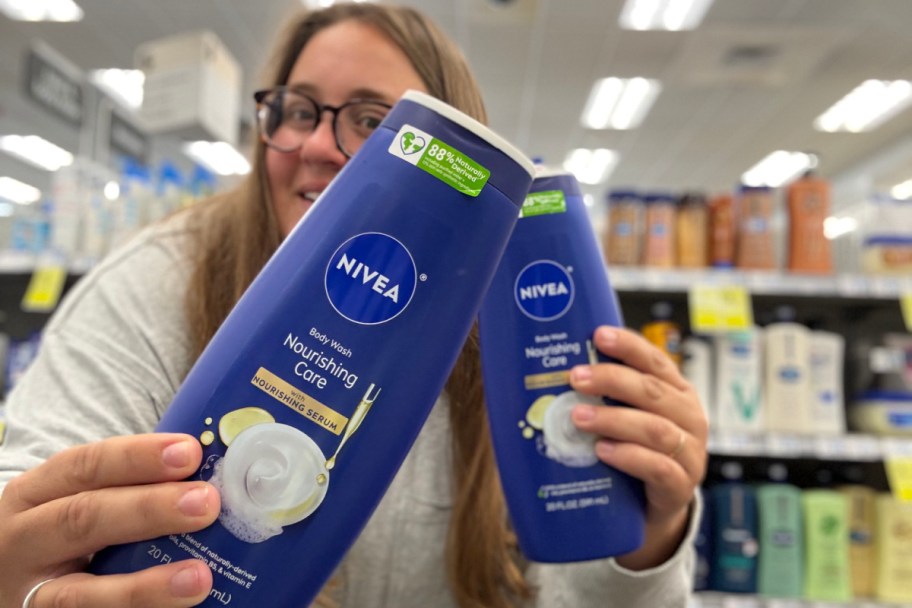 woman holding two body washes in store