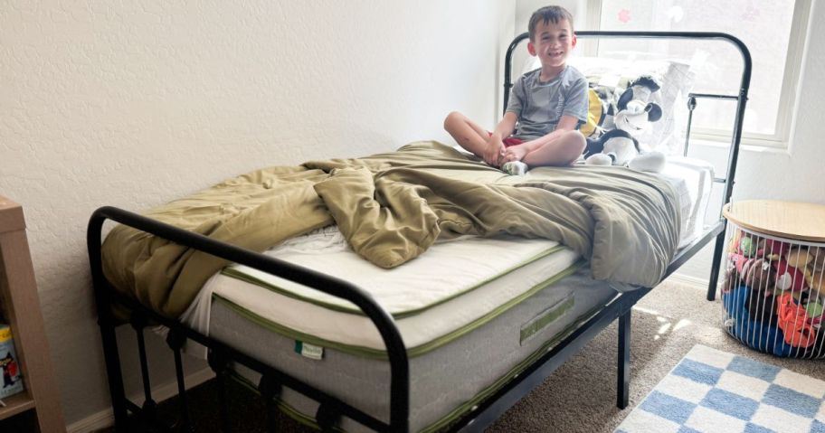 kid sitting on novilla mattress