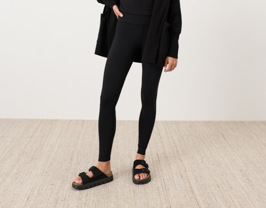 woman modeling black leggings with black birks